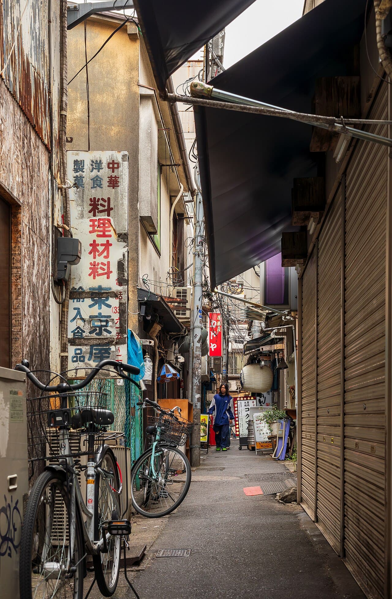 A narrow back alley in Kōenji, Suginami, Tokyo — the kind of street width at the center of Japan's road-frontage rebuild rule, not a specific property discussed in this article